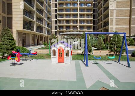Area intrattenimento. Parco giochi per bambini nel centro divertimenti. Plastica bambini giocare casa . I bambini oscillano in un parco. Plastica e blu E verde Vuoti Foto Stock