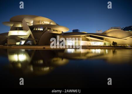 Il Museo Nazionale del Qatar si riflette in una piccola piscina esterna a Doha. Foto Stock