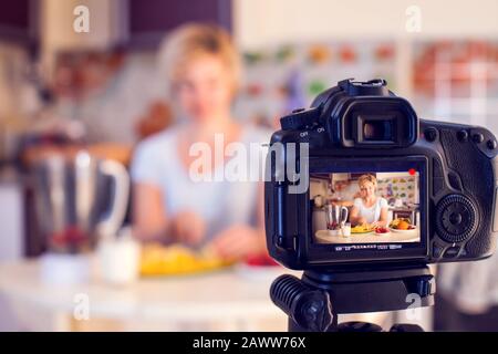 Donna cibo blogger cucina di fronte alla fotocamera recordindd video. Concetto di persone, media e tecnologia Foto Stock