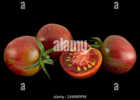 Pomodori marroni ciliegini con colseup isolato su sfondo nero Foto Stock