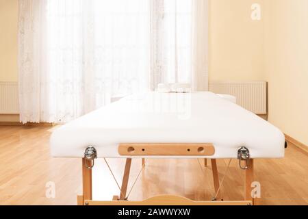 Interno di una sala di trattamento con massaggio o terapia fisica con lettino. Foto Stock