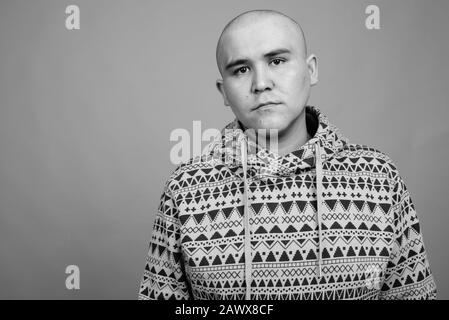 Ritratto di giovane uomo asiatico calvo che indossa felpa con cappuccio Foto Stock