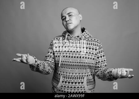 Ritratto di giovane uomo asiatico calvo che indossa felpa con cappuccio Foto Stock