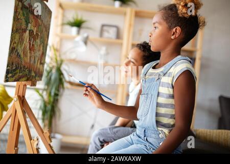 Carino Bambini ragazza ragazzo e pittura insieme. Educazione, arte, il divertimento e la creatività del concetto. Foto Stock