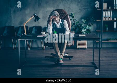 Full lunghezza foto minded pensive confuso vecchio nonno agente immobiliare Sit sedia tavolo lavoro computer cant fine azienda di sviluppo rapporto Foto Stock