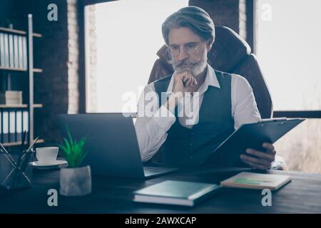 Primo piano ritratto del suo bel bel bello fiducioso serio messo a fuoco capelli grigi Signore seduto in sedia alla ricerca dati reddito utile crescita Foto Stock