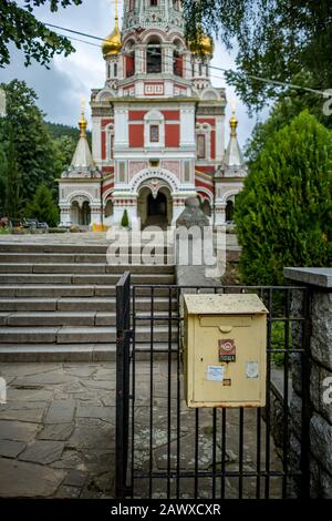 Selettiva poco profondo fuoco sulla vecchia scatola gialla arrugginita posta alla recinzione di entrata della chiesa russa Memoriale di Shipka, Bulgaria Foto Stock