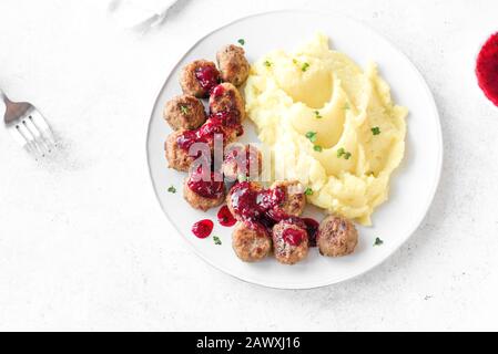 Polpette svedesi tradizionali con purè di patate e salsa di mirtilli, fondo bianco. Polpette di manzo arrosto, cibo scandinavo confortevole. Foto Stock