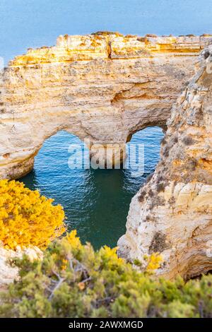 Bella vista di Praia da Marinha. Rocce, scogliere e piante verdi in Algarve, Faro, Portogallo. Acque turchesi dell'oceano Atlantico. Forma del cuore nelle rocce Foto Stock