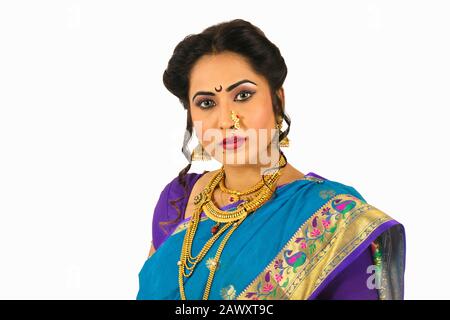 Modello indiano che indossa tradizionale saree Maharashtria, collana, anello del naso e grovigli, usura nuziale e guardando lateralmente Foto Stock