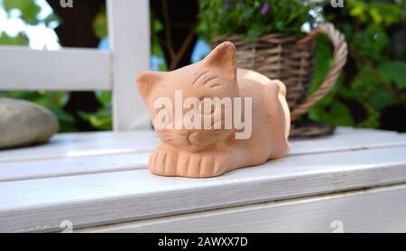 Carino gatto di terracotta su banco Foto Stock