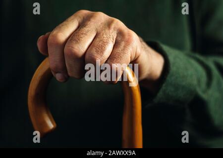 Mano di un vecchio che tiene un bastone da passeggio Foto Stock