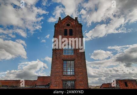 La torre di una vecchia birreria abbandonata fatta di mattoni in stile industriale Foto Stock