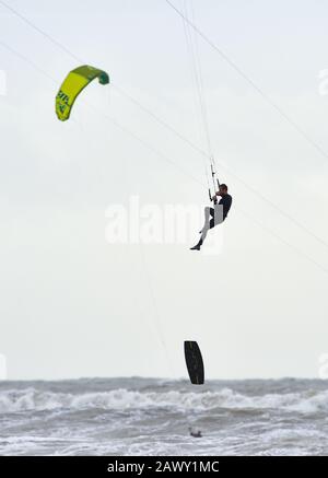 Worthing UK 10th Febbraio 2020 - UN kite surfer perde il suo bordo fuori dalla spiaggia di Goring vicino Worthing in Sussex occidentale come fanno il massimo della coda di Storm Ciara che ha tradito la Gran Bretagna durante il fine settimana: Credit Simon Dack / Alamy Live News Foto Stock