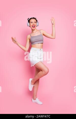 Foto a tutta lunghezza di funky millennial girl dance ascoltare musica  radio canzone danza cantare abbigliamento casual stile estate cuffia  isolato colore rosa Foto stock - Alamy