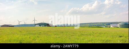 Fattoria con fienile e pianta di biogas, prato verde di fronte Foto Stock
