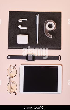 Elegante composizione flatlay desktop per ufficio su sfondo rosa pallido, verticale dall'alto Foto Stock