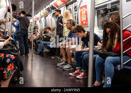 New York, Stati Uniti d'America - 7 giugno 2019: Passeggeri che viaggiano nella metropolitana di New York nell'ora di punta Foto Stock