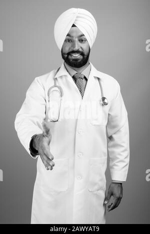 Giovani indiani barbuto Sikh medico uomo indossa turbante Foto Stock