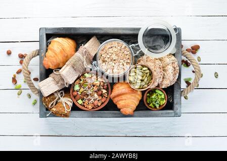 Bar con farinata d'avena, muesli, lino, spuntini sani. Su uno sfondo di legno bianco. Vista dall'alto. Spazio libero per il testo. Foto Stock