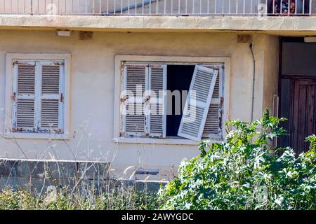 Dettaglio di abbandonato grunge giallo pietra rurale casa con finestra rotto e cactus crescente nel giardino, Mediterraneo regione del mare, Malta Foto Stock