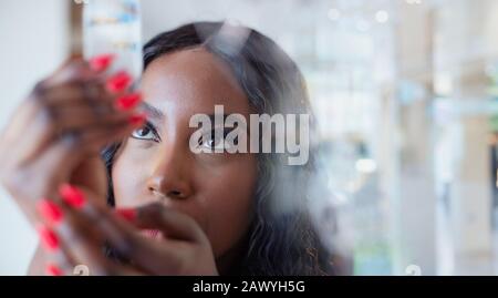 Primo piano curioso giovane donna che esamina cristallo Foto Stock