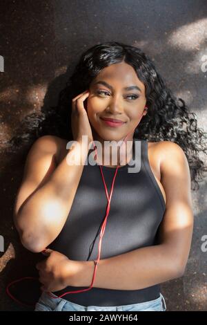 Felice giovane donna l'ascolto di musica con le cuffie Foto Stock