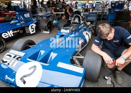 Un meccanico controlla le pressioni degli pneumatici su Tyrrell-Cosworth 003 nei box al Goodwood Festival of Speed 2018. Foto Stock
