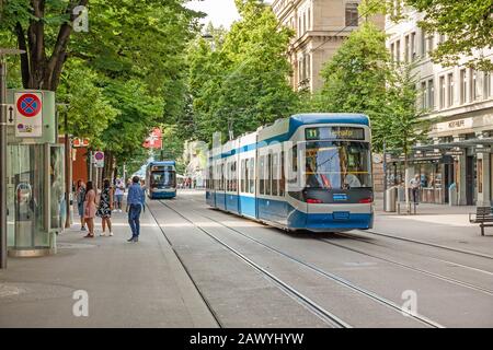 Zurigo, Svizzera - 10 giugno 2017: Passeggiata per lo shopping chiamata Bahnhofstrasse, città interna di Zurigo. Tram / treno di fronte. Foto Stock