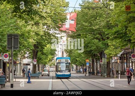 Zurigo, Svizzera - 10 giugno 2017: Passeggiata per lo shopping chiamata Bahnhofstrasse, città interna di Zurigo. Tram / treno di fronte. Foto Stock