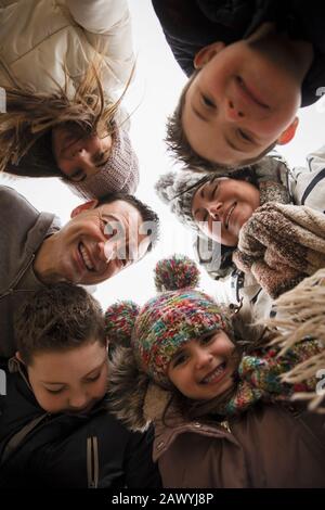 Ritratto felice famiglia con Down sindrome bambino in huddle Foto Stock