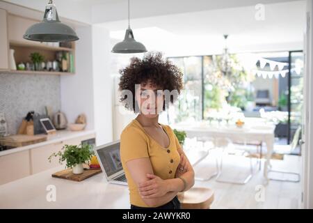 Ritratto sicuro giovane donna freelancer in cucina Foto Stock