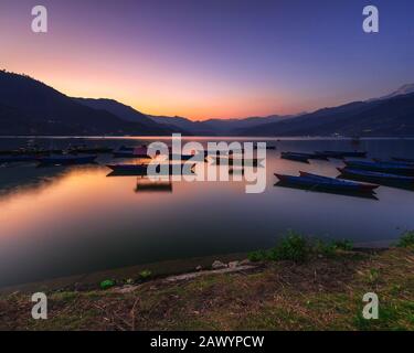 Bel tramonto sul lago di Phewa e colorato parcheggio in barca sul lago.Pokhara Nepal. Foto Stock