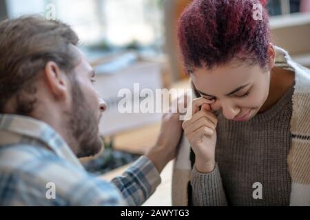 Piangendo la ragazza accanto all'uomo barbuto rassicurandola. Foto Stock