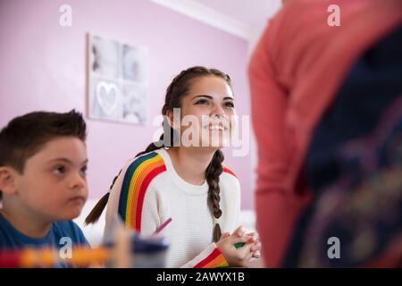 Ragazza felice teenage che gioca con fratelli Foto Stock