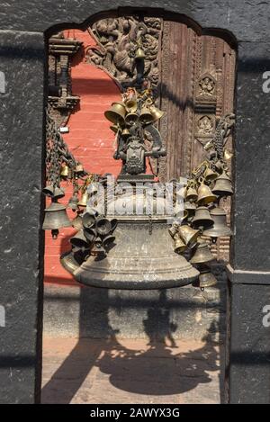 Molte campane buddiste dorate con i desideri ad un tempiale di Patan vicino a Kathmandu in Nepal Foto Stock