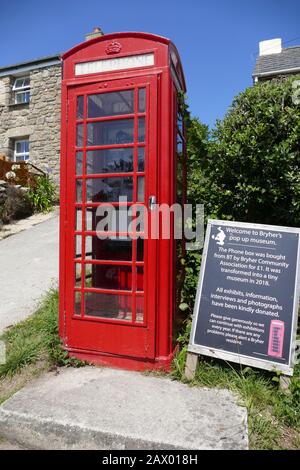 Vecchia cassetta telefonica rossa utilizzata come museo sull'isola di Bryher Foto Stock