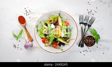 Insalata con formaggio feta, noci e pomodori ciliegini. Nella piastra. Stile rustico. Vista dall'alto. Spazio libero per il testo. Foto Stock