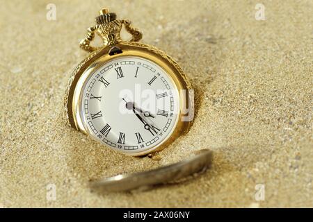Orologio tascabile nella sabbia - Concetto di passaggio del tempo Foto Stock