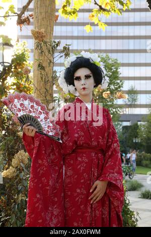 Timisoara, Romania- 09.06.2019 statua vivente di una geisha giapponese. Donna vestita di kimono posa come una statua umana realistica in un parco. Foto Stock