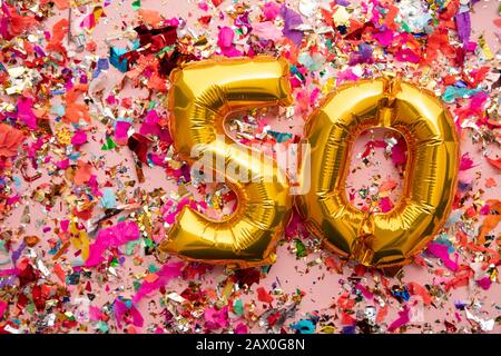 Numero 50 oro compleanno palloncino celebrazione su uno sfondo confetti glitter Foto Stock