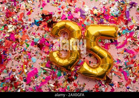 Numero 35 oro compleanno palloncino celebrazione su uno sfondo confetti glitter Foto Stock