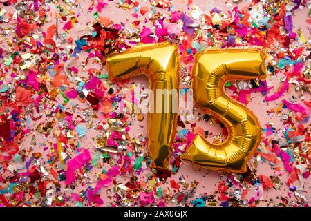 Numero 75 oro compleanno palloncino su sfondo confetti glitter Foto Stock