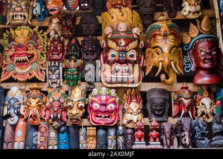 Maschere di legno colorate e artigianato in vendita presso il negozio nel quartiere Thamel di Kathmandu, Nepal. Foto Stock