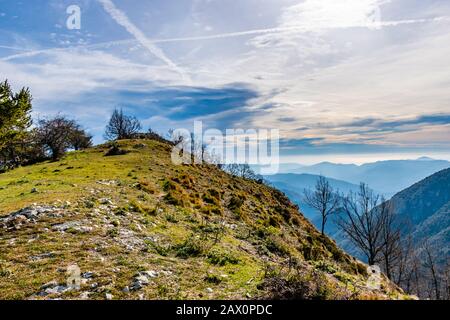 Bellissimo e affascinante paesaggio delle stratificate nebbiose Alpi francesi catena montuosa in Alpes-Maritimes nel pomeriggio durante una giornata di sole Foto Stock