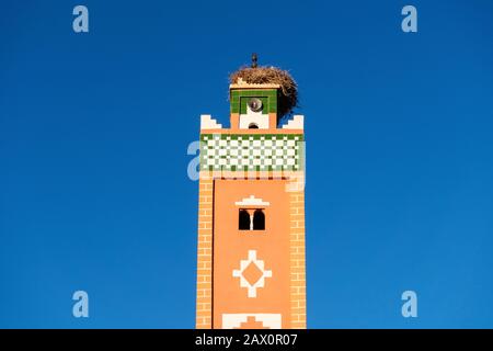 Minareto di moschea con nido di cicogne sulla cima in Ait ben Haddou, Marocco Foto Stock