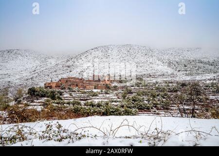 Remoto villaggio berbero dopo la caduta di neve in montagne Atlas, Marocco Foto Stock