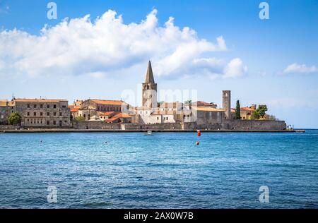 Vista panoramica panoramica dello storico skyline della città adriatica di Porec con acque blu intenso in una giornata di sole in estate, Istria, Croazia Foto Stock