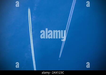 Due aerei che passano in altitudine in un cielo blu visto da terra su Londra, Inghilterra Foto Stock