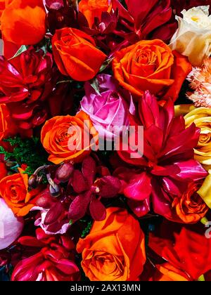 Bouquet di fiori, composizione ravvicinata di un bouquet di fiori, rose rosse, girasoli, foglie verdi. Decorazione floreale, regalo per il giorno delle donne, matrimonio Foto Stock